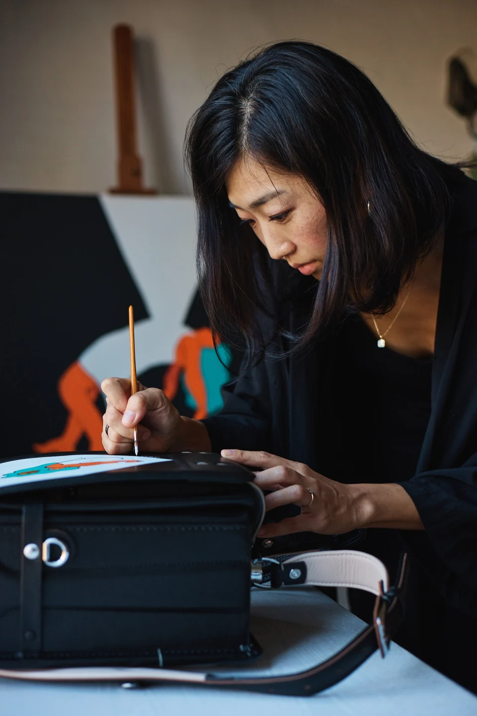 Shoko painting a colourful illustration with a fine brush.